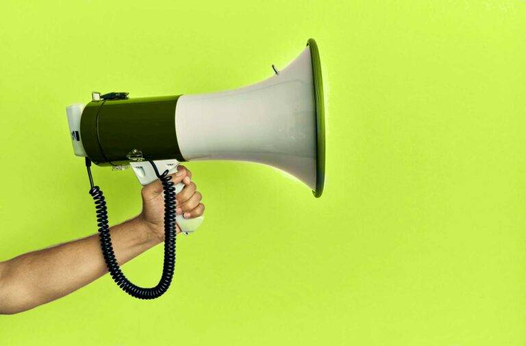 Ein Foto eines Megaphone vor einem Limettengrünen Hintergrund. Es symbolisiert eine wichtige Mitteilung.