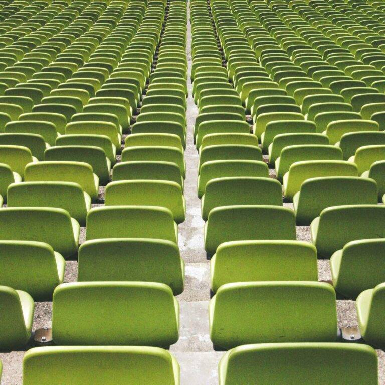 Ein Bild von vielen Reihen von grünen Plastiksitzen in einem Stadium. Es symbolisiert Effizienz.