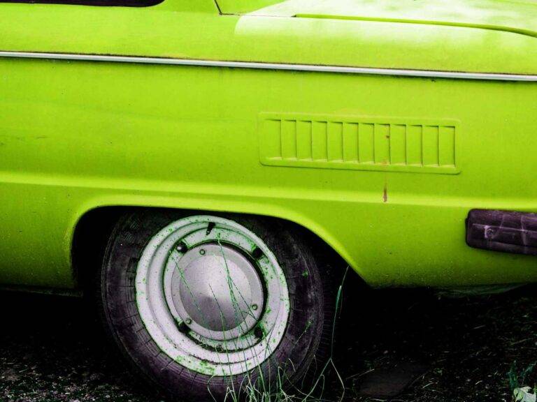 Ein Bild von einem Auto mit hellgrünen Lack. Im Fokus sieht man einen Autoreifen. Das Bild symbolisiert technisches Können.