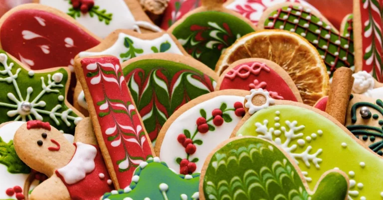 Ein bunter Teller mit weihnachtlich verzierten Plätzchen in verschiedenen Formen, darunter Lebkuchenmänner, Sterne und Herzen, kunstvoll dekoriert mit rotem, grünem und weißem Zuckerguss.