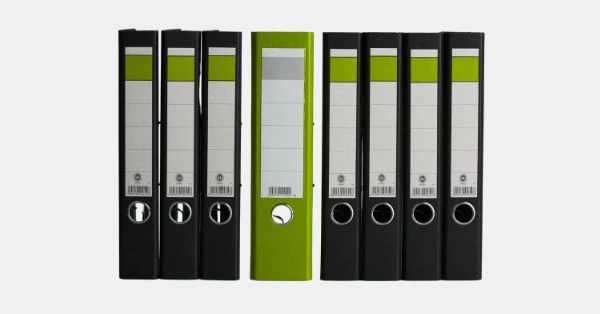 Mehrere Aktenordner in Schwarz und Grün als Symbol für strukturierten Aktenplan und systematische Schriftgutverwaltung in Organisationen.