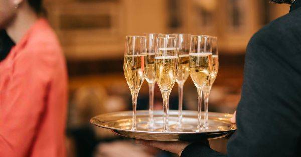 Tablett mit Sektgläsern bei einem exklusiven Networking Event, das eine stilvolle Atmosphäre für Business-Austausch und persönliches Netzwerken bietet.