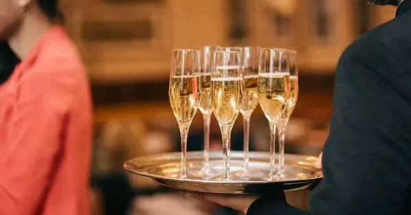 Tablett mit Sektgläsern bei einem exklusiven Networking Event, das eine stilvolle Atmosphäre für Business-Austausch und persönliches Netzwerken bietet.