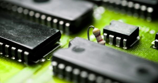 Nahaufnahme einer grünen Leiterplatte mit Mikrochips als Symbolbild für KI im Projektmanagement. Das Bild visualisiert digitale Technologien, Automatisierung und datenbasierte Prozesse in modernen Projektumgebungen.